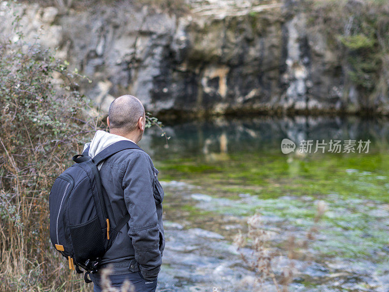 人在岩石上观察Pozo Azul de Covanera，布尔戈斯，西班牙